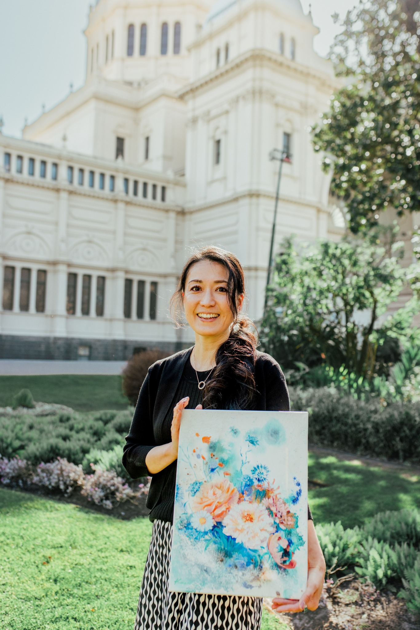 Artist Kaori holding one of her paintings